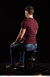 Tomas Salek  blue jeans dressed grey shoes red t shirt sitting whole body  jpg